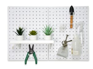 Three pots of succulents placed on a pegboard, along with a spray bottle, small shovel, and gardening tools.