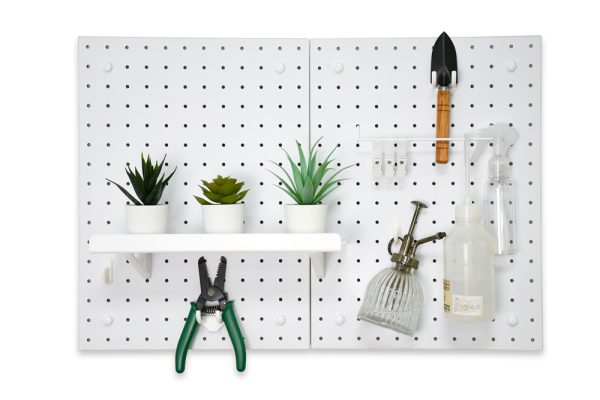 Three pots of succulents placed on a pegboard, along with a spray bottle, small shovel, and gardening tools.